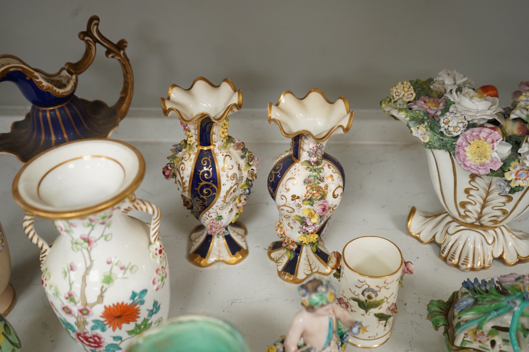 Large group of 19th/20th century English ceramics, to include a Rockingham basket, other English porcelain flower encrusted vessels, a Copeland and Garrett ewer, a Minton Sevres style beaker, a Wedgwood agate ware jug, R